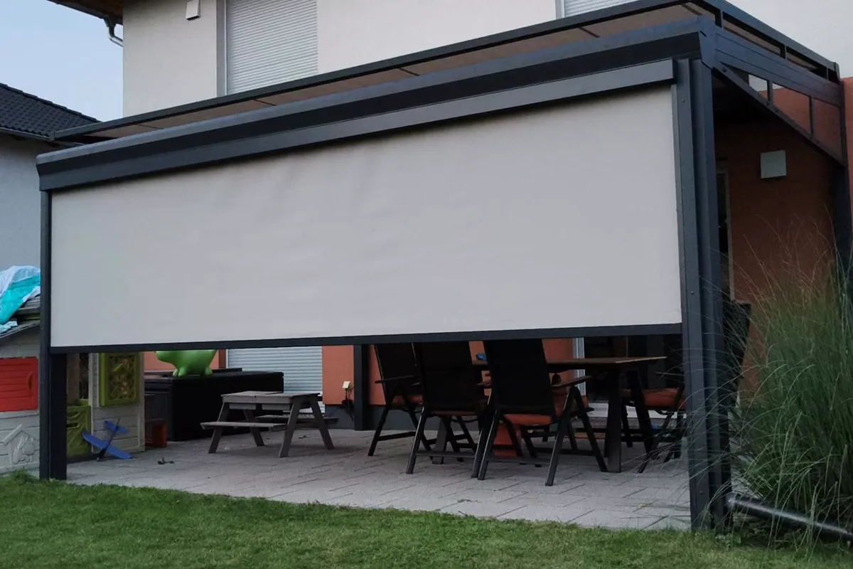 Terrassenüberdachung mit heruntergelassener Senkrechtmarkise als Sicht- und Sonnenschutz